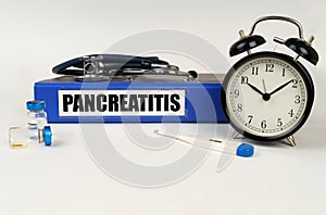 On a white surface, a thermometer, a stethoscope and a folder with the inscription - Pancreatitis