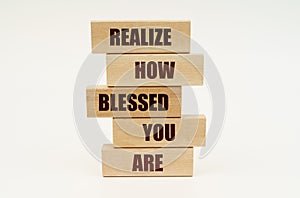 On a white surface are wooden blocks with the inscription - Realize How Blessed You Are