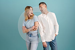 White surprised couple exclaiming and looking at each other