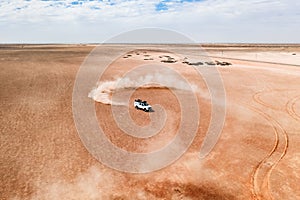 A white SUV car dune drifting in desert