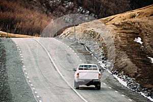 White SUV Car Moving On Mountain Road In Autumn Mountains Landsc