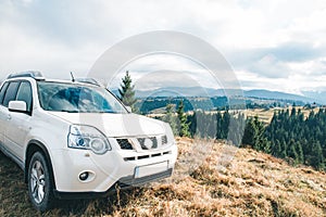 white suv car at top of the hill mountains on background