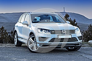 White SUV volkswagen touareg stands at the exit of the mountain road