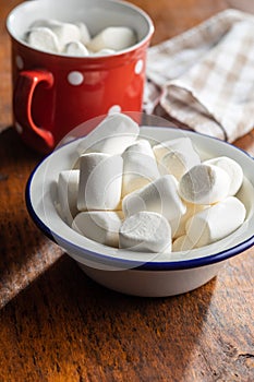 White sweet marshmallows candy in mug on a kitchen table