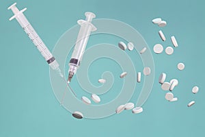 white syringes and tablets on a green background