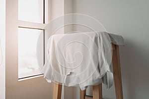 White t-shirt hanging on the chair.