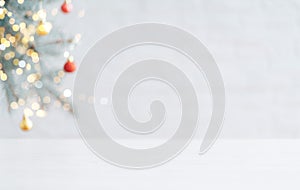 White table in against of blurred branch of Christmas tree with bauble