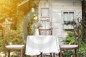 White table and chairs in beautiful garden.