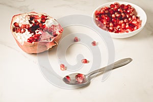 white table of grenades fruit, the purified red seeds of pomegranate in a bowl/on a white table of grenades fruit, the purified