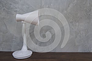 White Table lamp isolated on wooden table wall gray background .