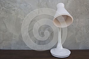 White Table lamp isolated on wooden table wall gray background .