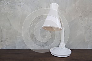 White Table lamp isolated on wooden table wall gray background .