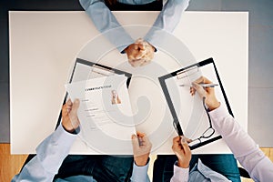 White table and people with legal pad and cv during recruitment interview