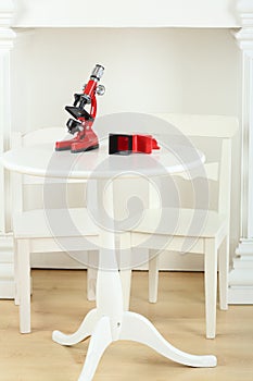 White table with red microscope and two childrens photo