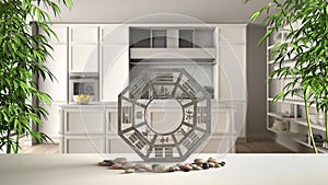 White table shelf with bagua, pebble stone and bamboo plants, classic kitchen with island in modern apartment, zen concept