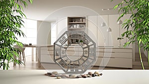 White table shelf with bagua, pebble stone and bamboo plants, modern white and wooden kitchen with island and stools, zen concept