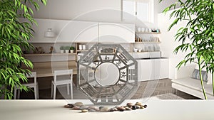 White table shelf with bagua, pebble stone and bamboo plants, white scandinavian kitchen with modern staircase, zen concept