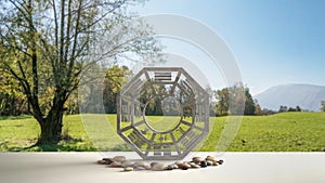 White table shelf with bagua and pebble stone, park meadow with green grass and tree, zen concept interior design, feng shui