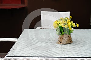 white table on terrace of house. wicker rattan chair on patio at