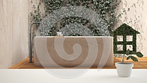 White table top or shelf with green plant in pot shaped like house, japanese bathroom, garden with ivy and bathtub in the