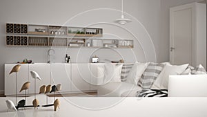 White table top or shelf with minimalistic bird ornament, birdie knick - knack over blurred contemporary living room with kitchen,