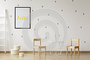 White table between wooden chairs in child`s room interior with