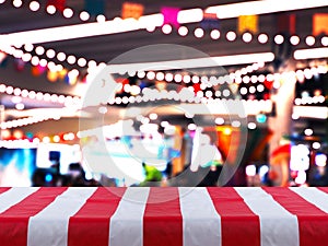 White tablecloth with red strips over blurred background of light decoration and bokeh party place