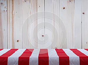 white tablecloth with red strips over pine wood wall background