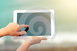 White tablet with a blank screen in the hands