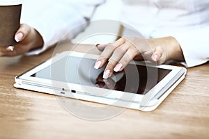 White tablet with a blank screen in the hands