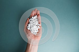 White tablets on a blue background are isolated. Hand with a tablet.