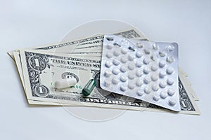 White tablets, pills and dollars