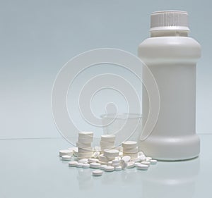 White tablets, white container for mixture and measuring cup