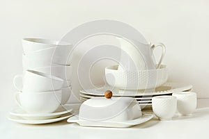 White tableware for serving. Crockery,dish, utensils and other different white stuff on white table-top. Kitchen still life as bac