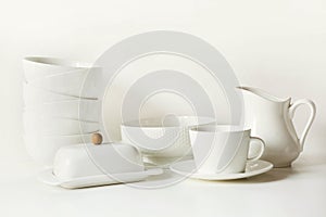 White tableware for serving. Crockery,dish, utensils and other different white stuff on white table-top. Kitchen still life as bac