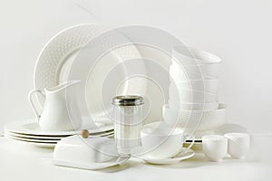 White tableware for serving. Crockery,dish, utensils and other different white stuff on white table-top. Kitchen still life as bac