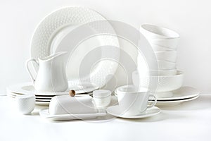 White tableware for serving. Crockery,dish, utensils and other different white stuff on white table-top. Kitchen still life. Copy