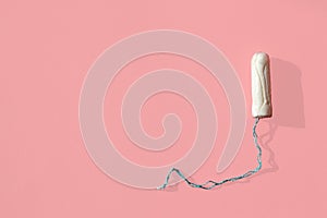 White tampon on pink background. Isolated on pink. Woman`s hygiene and health