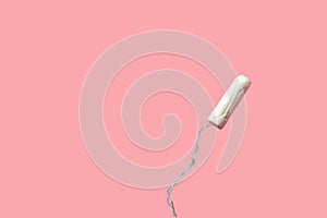 White tampon on pink background. Isolated on pink. Woman`s hygiene and health