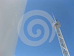 White tank and tower lighting on the sky background.