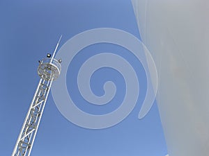 White tank and tower lighting on the sky background.