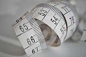 White tape measure tape measuring length in meters and centimeters on the isolated surface as symbol of tool used by tailor photo