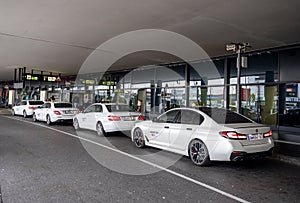 White taxi cars like BMW and Mercedes in front of the Flughafen Wien-Schwechat airport