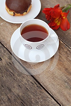 White Tea Cup Chocolate Donut Orange Red Flower Alstromeria Astromeria over Rustic Wooden Background. Copy space