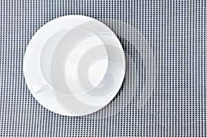 White tea cup and plate on gray cloth table, top view