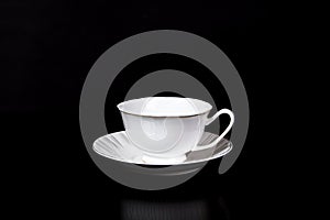 White tea Cup in a saucer on a black background