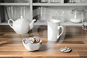 White tea cup, teapot and cookies