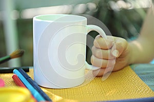 White tea mug empty space mockup, child hand with empty white cup