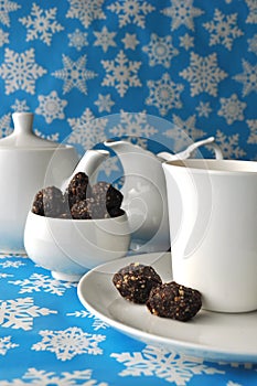 White tea set with chocolate walnut and date sweets on blue winter background