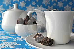 White tea set with chocolate walnut and date sweets on blue winter background